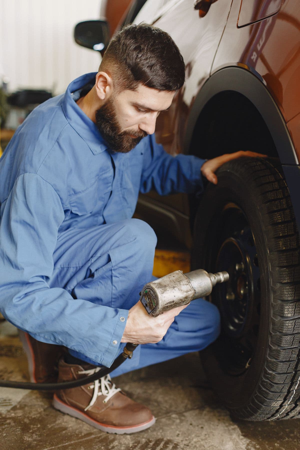 Mechanic fitting a tyre with an impact wrench