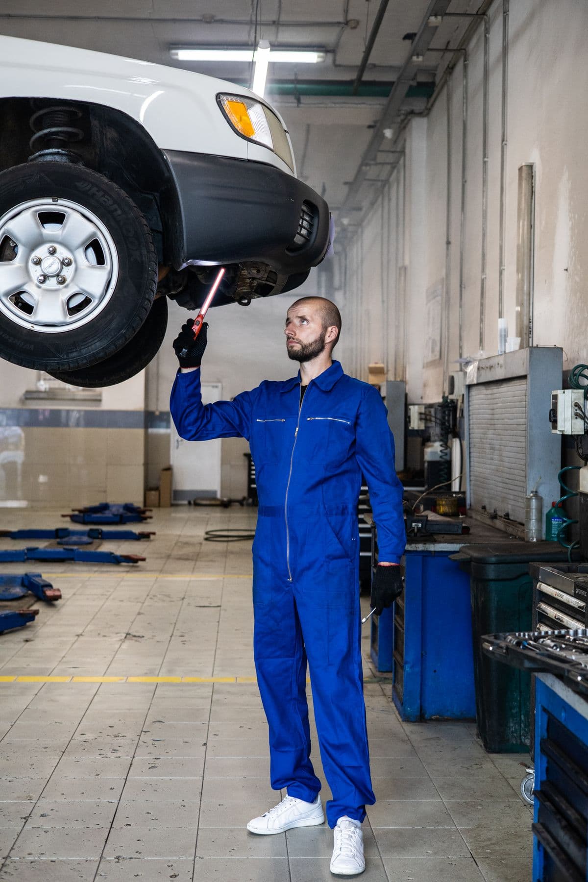 Mechanic working underneath a raised vehicle